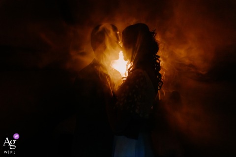 In Sologne, France, the bride and groom are photographed in silhouette with dramatic backlighting, creating a striking wedding-day portrait defined by bold shapes and luminous light.