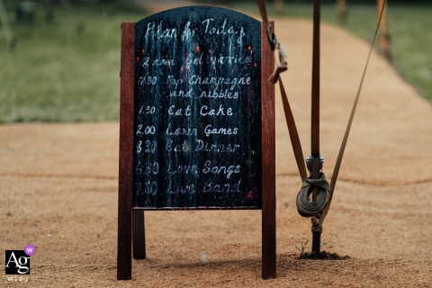 In Elkesley Village, Nottinghamshire, England, the wedding day's schedule, handwritten in chalk, is partially washed away by the rain, creating a humorous reminder that even the best-laid wedding plans cannot control the weather.