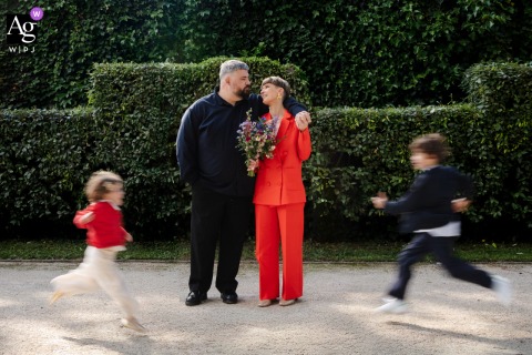 At Maison d'Anthouard in Lyon, France, the couple is photographed with their children in motion, creating a lively family portrait filled with energy and wedding-day joy.