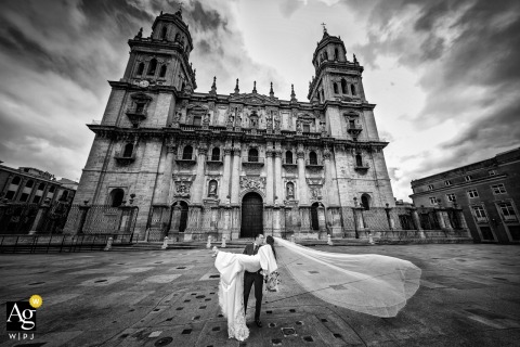 Historic Grandeur Surrounds The Couple At Cathedral Of Jaén In Jaén, Spain At Cathedral of Jaén in Jaén, Spain, the bride and groom pose together for an elegant wedding-day portrait, framed by the grandeur and historic character of the cathedral setting.