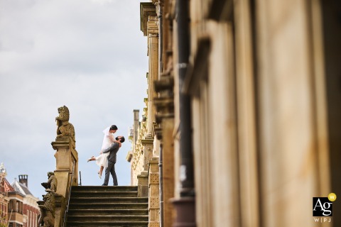 Historic Stairs Frame The Couple In Leiden, Netherlands During Their Wedding Portrait Session In the city center of Leiden, Netherlands, the couple stands together at the top of a staircase, creating an elegant wedding-day portrait framed by the character of the historic setting.
