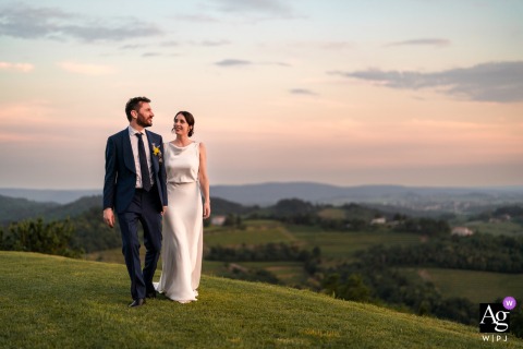 At Baronesse Tacco in San Floriano del Collio, Gorizia, Italy, the newlyweds walk together at sunset, framed by a sweeping view of the surrounding hills.