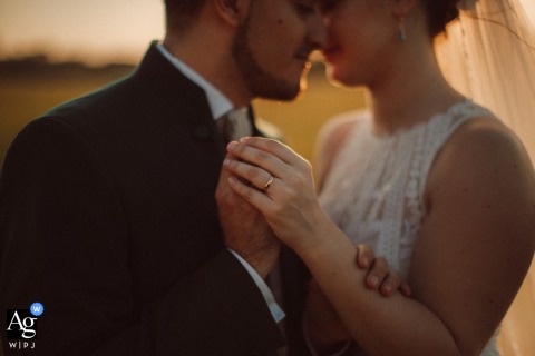 At Tenuta Cambiaga near Milan, Italy, a detail of the bride’s hand highlights her wedding ring as she and the groom stand face to face, sharing a quiet and intimate moment together.