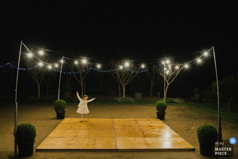 New South Wales girl dancing alone at the reception outdoors under lights at night - Australia wedding photography