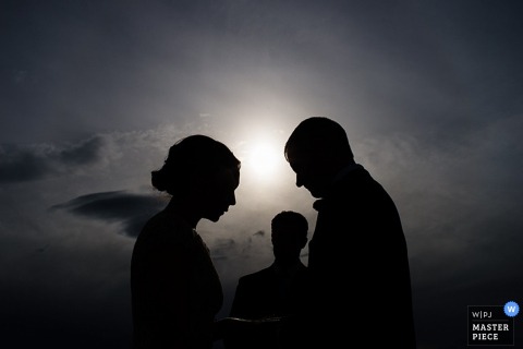 Lake Tahoe bride and groom silhouetted during the outdoor ceremony as the sun is setting Lake Tahoe bride and groom silhouetted during the elopement outdoor ceremony as the sun is setting - California wedding photo