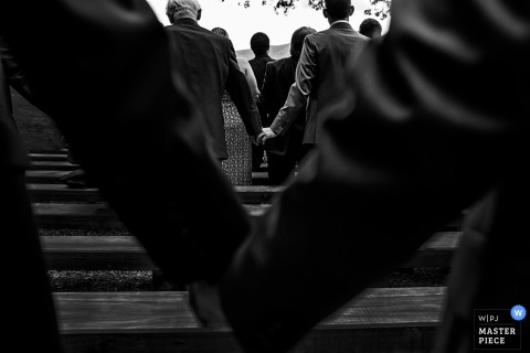 Black and white photo of men holding hands during the ceremony by a Washington, D.C. wedding photographer.