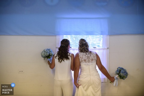 The bride looks out a window in this photo by an Omaha, NE wedding photographer.