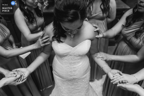 Todas as damas de honra colocam as mãos na noiva nesta foto em preto e branco tirada por um fotógrafo de casamento de São Francisco.