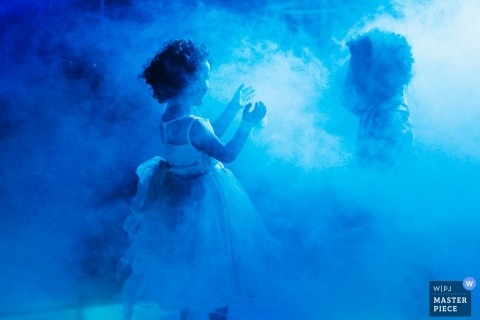 Lyon Wedding Photography | Image contains: kids girl dress play fog machine blue lights boy reception