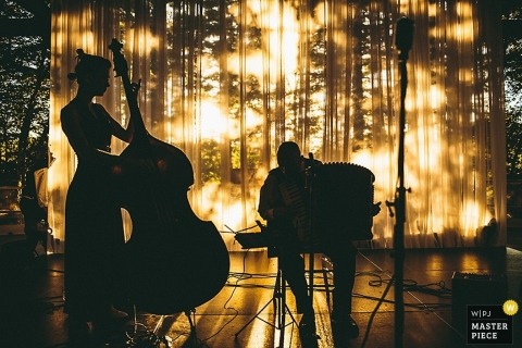 Wedding Photographer in Hudson Valley | Image contains: reception, musicians, silhouette, cello, outdoors