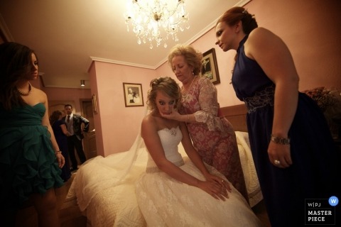 Wedding image of a Castile and León mother putting on the bride's veil