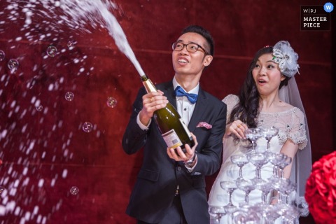 Guangdong wedding photographer captured this photo of the groom spraying champagne out of the bottle while the bride stands by surprised Guangdong wedding photographer captured this photo of the groom spraying champagne out of the bottle while the bride stands by surprised