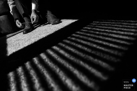 Lake Tahoe groom ties his shoes before the wedding - California wedding photojournalism 