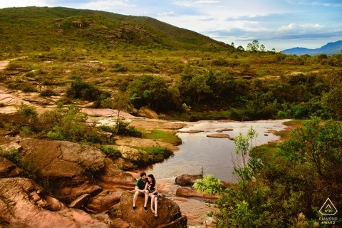 Engage couple perched on a rock above the River in Brazil for the pre-wedding portrait
