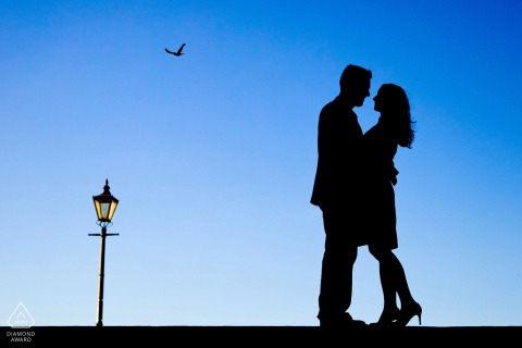 Hérault engagement pictures of a couple silhouetted with a nearby lamp post | Occitanie photographer pre-wedding photo shoot session