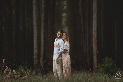 Minas Gerais couple portrait with the trees of a stark forest, a few trunks emphasizing the natural surroundings and intimate connection