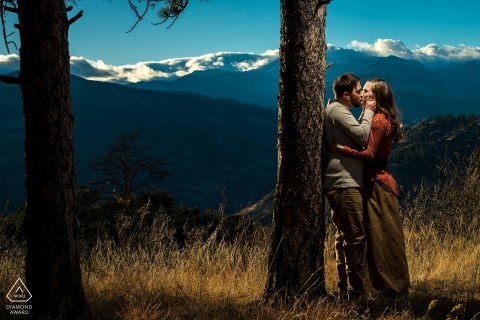 O casal de Boulder, Colorado retratado como eles se beijam na frente de uma cordilheira