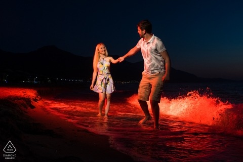 Engaged couple walking in the sea at evening for their engagement session