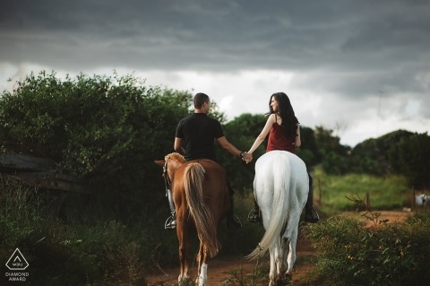 Casal de Brasília, montando cavalos durante a sessão de fotos de noivado