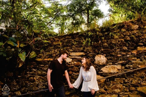 Ouro Preto, MG couple holding hands by rock wall during photo shoot