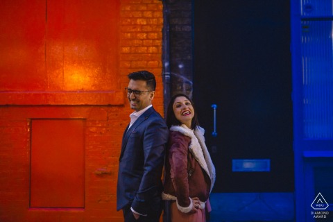 Shoreditch London engagement |  The colours of the wall mimicing the colours the couple are wearing (red/orange and blue)
