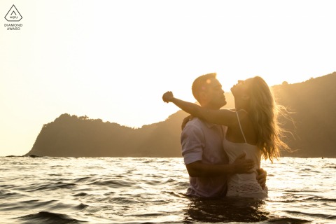 Photographie de mariage à São Paulo montrant un couple Brésil Cambury au coucher du soleil dans les eaux de la plage