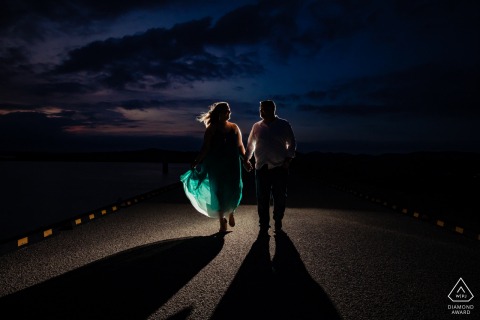 True Love Engagement Portrait Session at Overlook Park in Canyon Lake displaying a couple walking into the light at night