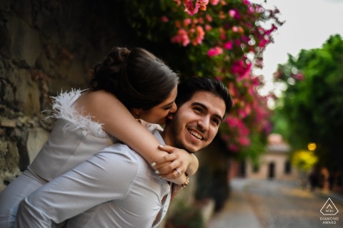 San Miguel de Allende couple e-shoot at Parque Juarez showing she she decided to bit his ear in a street full of colors and with a 50 mm lens this spectacular background is formed
