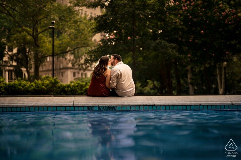 Outdoor Rittenhouse Square, Philadelphia couple engagement photography portrait with a poolside kiss
