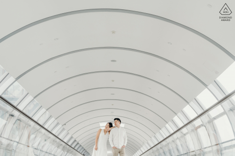 Singapore pre-wedding engagement image-session at Jewel, Changi Airport of the couple as they pose at the walkway between Terminal 1 and the Jewel annex Singapore pre-wedding engagement image-session at Jewel, Changi Airport of the couple as they pose at the walkway between Terminal 1 and the Jewel annex