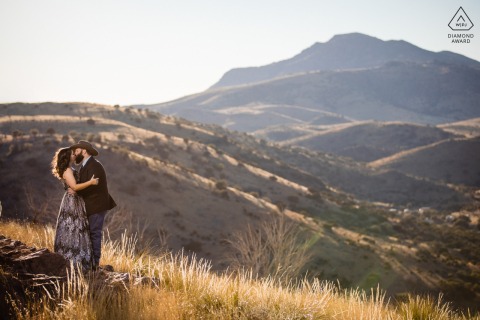 Davis Mountain State Park post proposal portrait photos of a happy Southern Texas couple kissing under the sun on the rolling desert hills