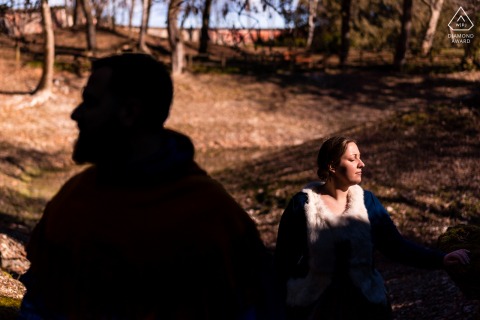 Udine Engagement. A young Italian couple posing during a pre wedding portrait session with Lights and shadows below the trees