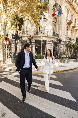 A newly engaged Buenos Aires couple walks in the city for an engagement announcement portrait in Argentina’s big, cosmopolitan capital city at the Plaza de Mayo