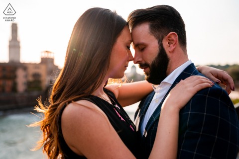 Verona announcement of engagement idea with the sunset of Italy and the couple by the water and Hugging