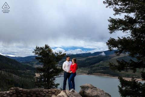 In the mountains of Breckenridge, Colorado, the couple is holding hands with big mountain scenery behind them