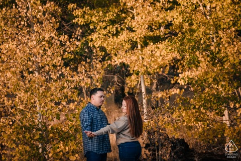 A Kahle Park, Lake Tahoe California couple shares a moment in the field together under trees showing their fall colors