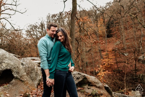 A couple embraces in a natural setting while the man tenderly holds the woman from behind, captured by a WPJA wedding photographer at Rambouillet