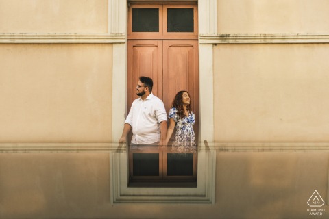 In Maceió, Brazil, a couple holds hands in a symmetrical composition, creating a visually harmonious scene.