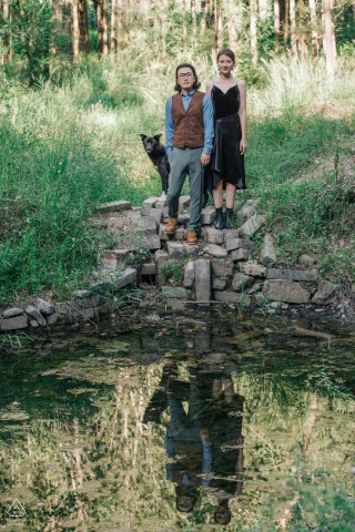 A captivating lifestyle couple portrait, set amidst the serene beauty of Huairou, Beijing, China. This family of three, accompanied by their beloved dog, share a picturesque session by the tranquil waters of a green forest.