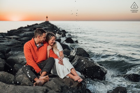 An artistic couple portrait by a NJ wedding photographer at Higbee's Beach, Cape May, capturing the Bride and Groom posing intimately on beach rocks at sunset.