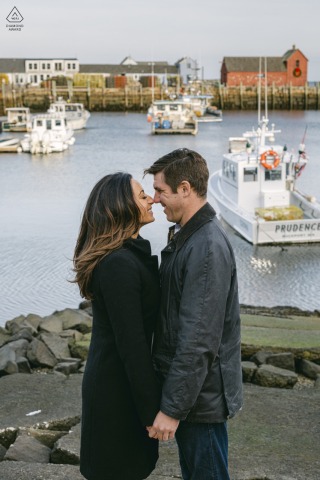 Harbor Harmony: Intimate Engagement Portrait at Motif #1, Rockport, MA Engaged couple posing intimately by the harbor near Motif #1 in Rockport, MA, captured by a fine art wedding photographer.