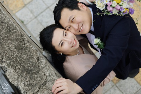 At the Bund in Shanghai, China, a couple gazes into the future, with urban streets as backdrop. A romantic portrait session capturing their love story.