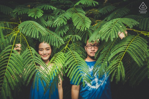 Romantic portrait in Khao Yai National Park - Thailand, featuring a couple framed by large green ferns, captured amidst the tranquility of nature.