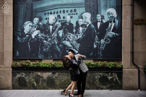 In Shanghai's Bund, the couple glows with music and movement on the wall behind them!