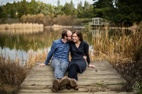 How cozy and sweet this Northern California couple looks in their engagement portrait by the old wooden boat dock in San Mateo.