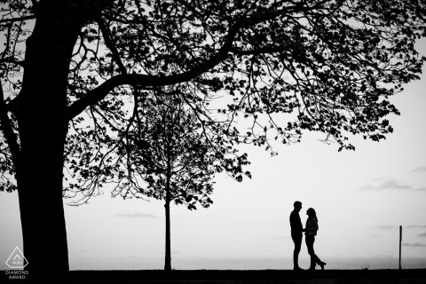 At Fullerton Beach in Chicago's Lincoln Park, a couple's silhouette is captured against the serene backdrop of the water, showcasing their connection in a tranquil, picturesque setting.