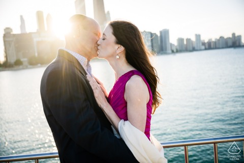 At Milton Olive Park in Chicago, IL, a couple takes an engagement photo at sunset, with the vibrant sky creating a breathtaking backdrop for their special occasion.