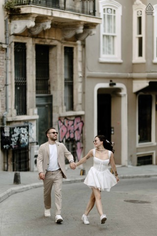 On Çukurcuma Street in Istanbul, a couple walks hand in hand, their excitement palpable as they navigate the charming, narrow streets, embracing the city's vibrant atmosphere.