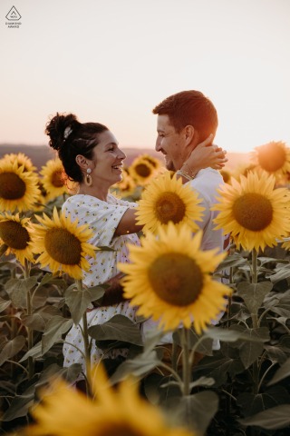 In Faux, Lot-et-Garonne, France, the engagement session unfolds amidst a sunflower field at sunset, capturing the vibrant and romantic essence of their love.