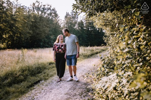 A couple joyfully walks and laughs during their engagement session at Jagdhaus im Kühl, Germany.